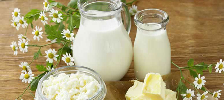 Vasos de leche con flores al rededor Image