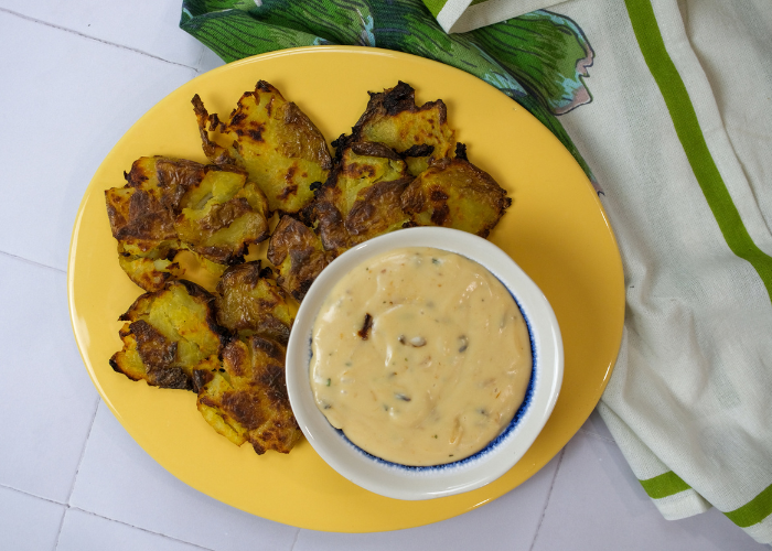Papas aplastadas con salsa de queso